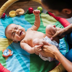 baby lying on a soft play mat, squirming and looking uncomfortable from baby growth spurts